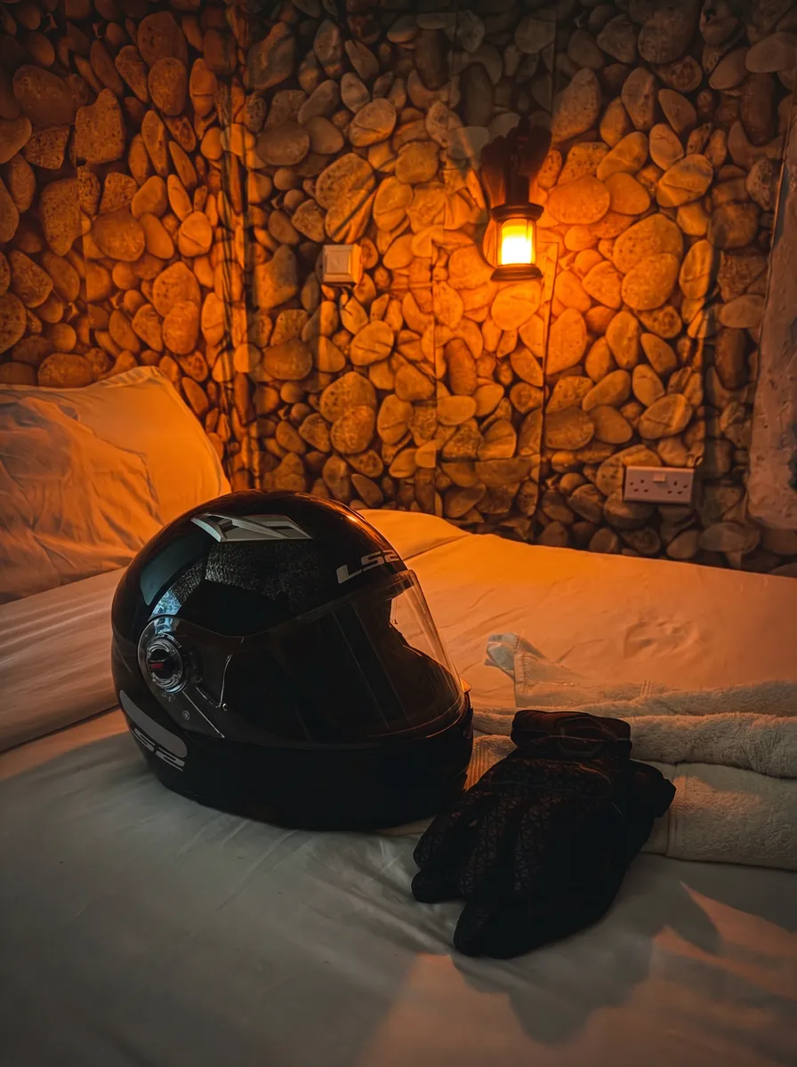 Helmet and gloves resting on a lodge bed
