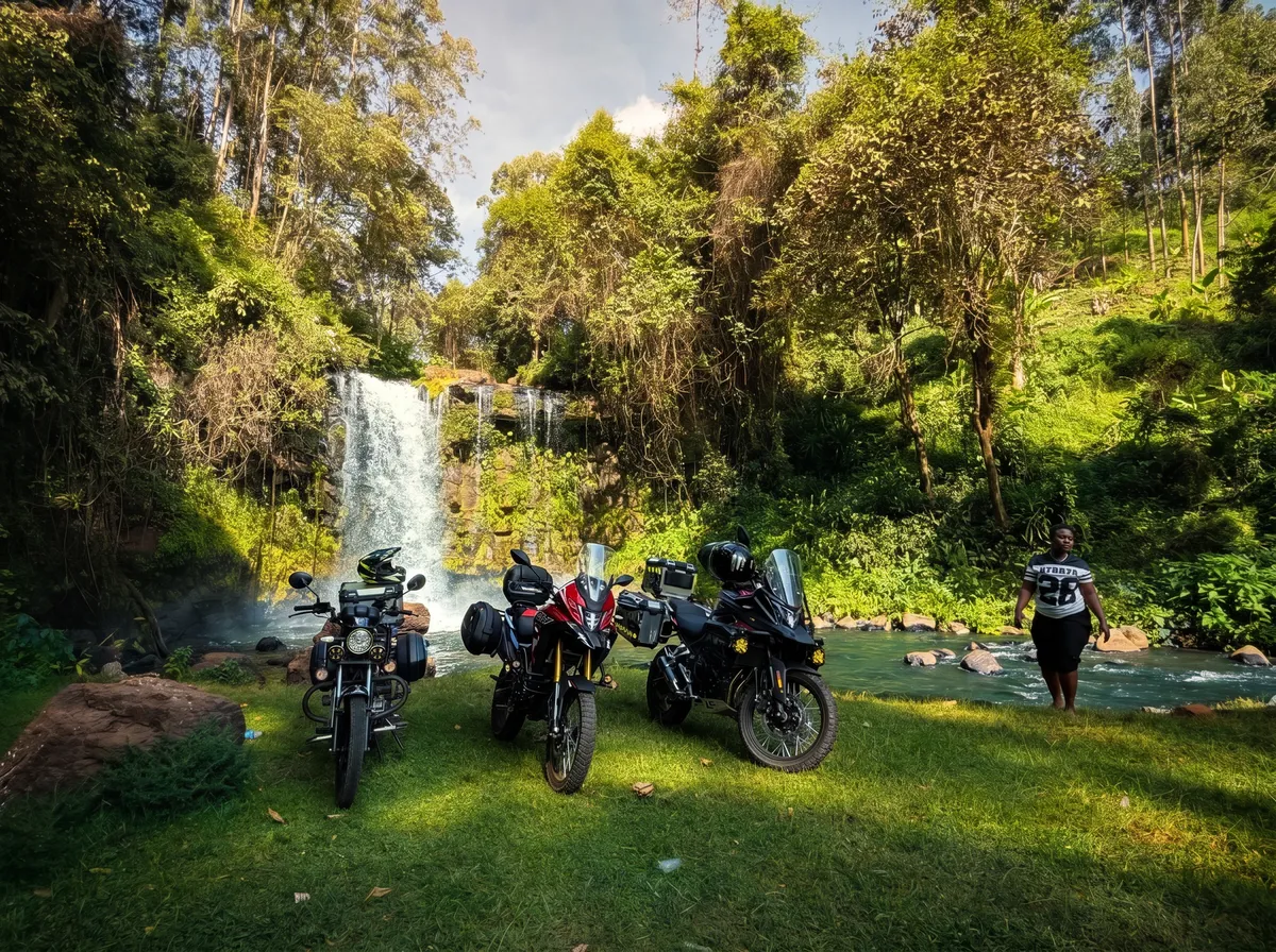 Three motorcycles parked by a waterfall in the highlands